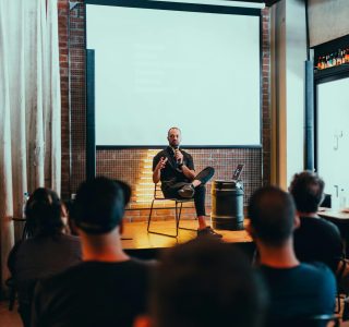 Speaker engages an audience during a business seminar in a modern conference room.